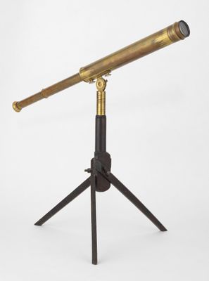 un télescope en laiton posé sur un trépied, avec un fond blanc