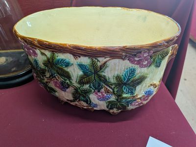 a large bowl sitting on a table next to a glass vase