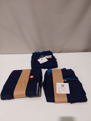 trois pantalons bleus posés sur une table blanche