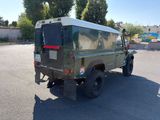a green land rover parked in a parking lot