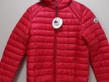 a red jacket hanging on a hanger on a wall