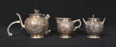 three pieces of silverware on a black surface with a black background