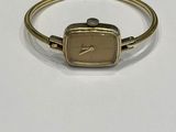 an image of a gold bracelet with a square shaped watch on it