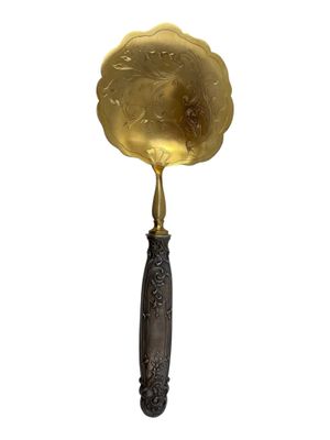 an antique brass spoon with a wooden handle and handle