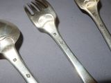 three spoons and a fork on a table