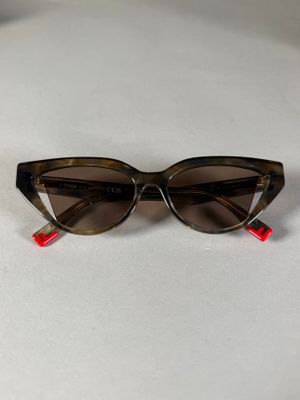 une paire de lunettes de soleil posée sur une surface blanche