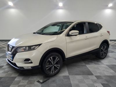 un SUV Nissan blanc garé sur un sol à damier dans un garage