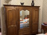 a bedroom with a bed, dresser, mirror and a dresser