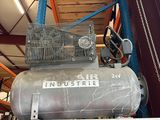 un gros compresseur d'air posé sur une étagère dans un entrepôt