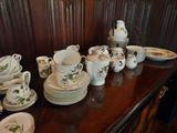 many plates and cups sitting on a wooden table