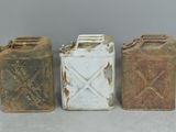 three old metal cans sitting next to each other on top of a table