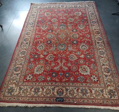 Un tapis persan ancien est exposé dans une pièce
