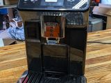 a coffee maker sitting on a wooden table in a room