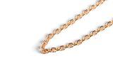 a close up of a gold chain on a white surface