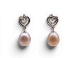une paire de boucles d'oreilles roses en perles et argent sur fond blanc