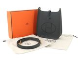 a black handbag with an orange box and a black belt