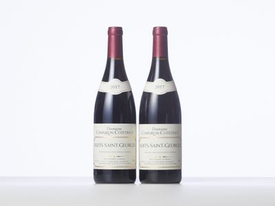 two bottles of wine sitting on top of a white table