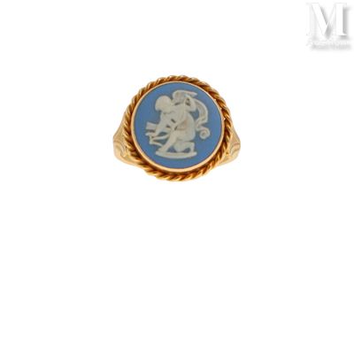 un gros plan d'une bague en or ornée d'un camée bleu et blanc