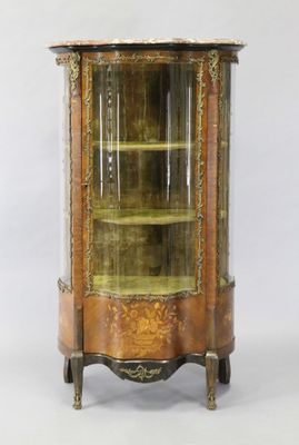 une vitrine ancienne avec une porte vitrée et des moulures dorées