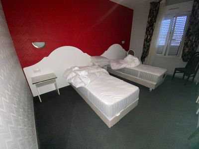 two twin beds in a room with a red wall