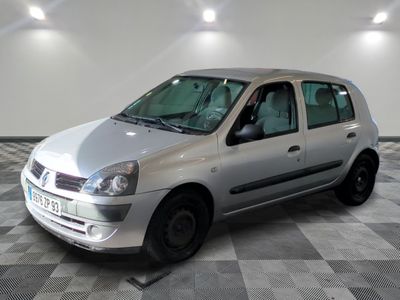 une petite voiture argentée garée dans une pièce au sol en damier