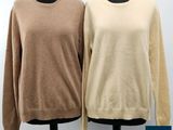 two women ' s sweaters on a mannequin stand
