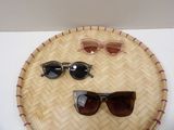 deux paires de lunettes de soleil posées sur un plateau, sur une table