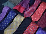 many different colored ties laid out on a black surface