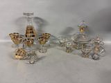 three pieces of glass with gold and silver decorations on a white surface