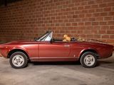 an image of a red convertible car parked in front of a brick wall