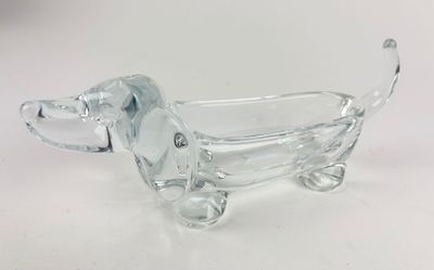 figurine de chien en verre transparent posée sur un socle blanc