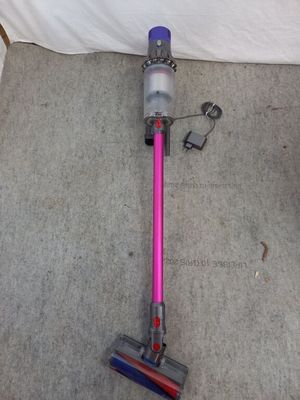 a pink and blue vacuum on the floor next to a white wall
