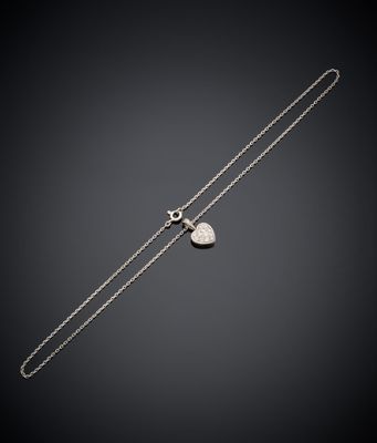 un collier en argent orné d'un pendentif en forme de cœur sur fond noir