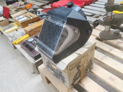 un téléviseur posé sur une palette, à côté d'autres objets