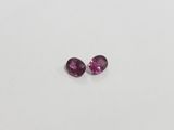 a pair of pink tourmaline gems on a white surface