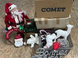 un Père Noël assis dans une boîte remplie de jouets