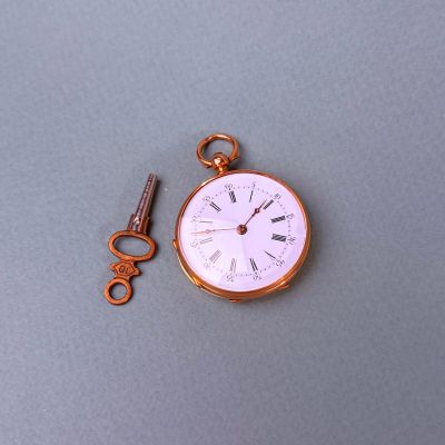 une montre de poche à laquelle est attachée une clé