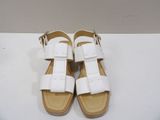 white leather sandals with buckles and straps on a white surface