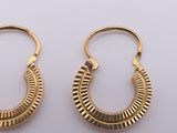 a pair of gold hoop earrings on a white surface