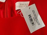 a close up of a label on a red dress on a hanger