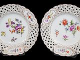 deux assiettes blanches ornées de motifs floraux sur un fond noir