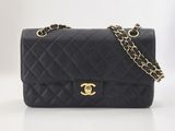 un sac à bandoulière Chanel en cuir matelassé noir, avec des finitions dorées