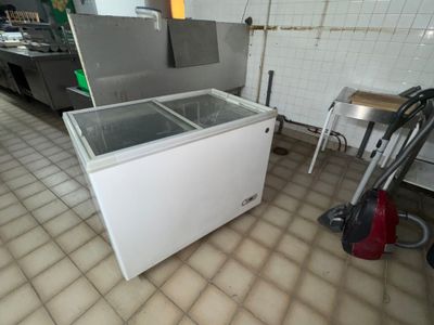 a small freezer sitting in the middle of a kitchen