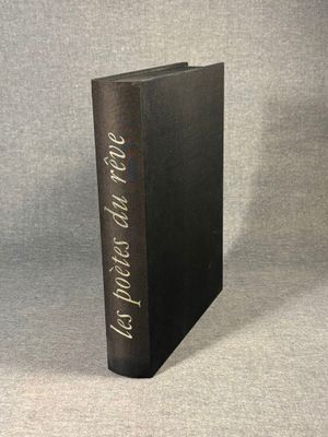 a black book sitting on top of a table next to a gray wall