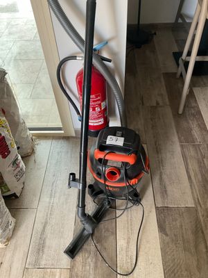 an orange and black vacuum cleaner sitting on top of a hard wood floor