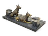 statue of two dogs on a bench with books and a box