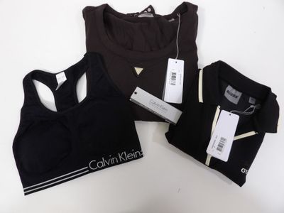 a close up of three black sports bra tops on a white table