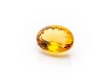 a yellow sapphire stone on a white background