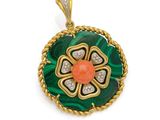 un gros plan d'un pendentif vert et orange sur fond blanc