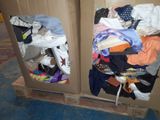 two cardboard boxes with clothes in them on a pallet